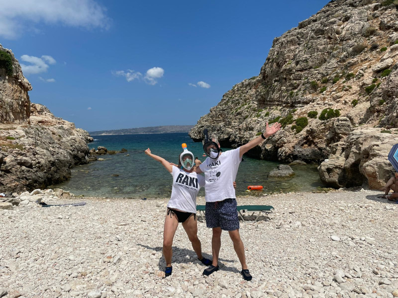 Twee mensen met snorkelmaskers op het strand met de zee op de achtergrond